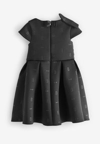 Vestido negro hecho de un tejido texturizado que presenta un sutil patrón de letras y corbatas. Mangas cortas, falda plisada y cierre de cremallera en la parte posterior.