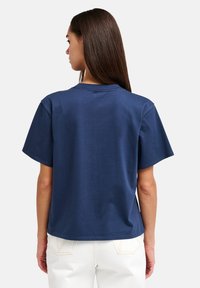 Μπλε ναυτικό βαμβακερό T-shirt με κοντά μανίκια και στρογγυλή λαιμόκοψη. Διαθέτει άνετη εφαρμογή και απαλό ύφασμα. Απλός σχεδιασμός στην πλάτη.