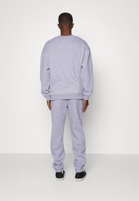 Endless Nights UNIFORM ESSENTIALS UNISEX - Calças de fato de treino - sport grey