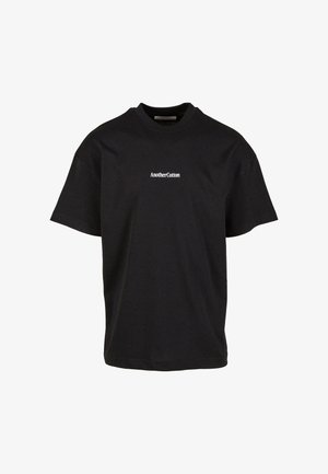 Čierne bavlnené tričko s uvoľneným strihom, okrúhlym výstrihom a krátkymi rukávmi, na prednej strane s bielym potlačeným logom "AnotherCotton".