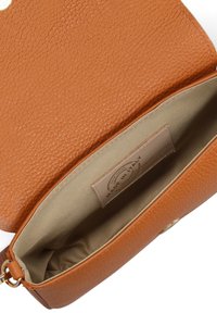 Borsa in pelle color tan con esterno testurizzato, apertura superiore che rivela un interno beige chiaro e un'etichetta che indica "Fatto in Italia". Dettagli in oro.