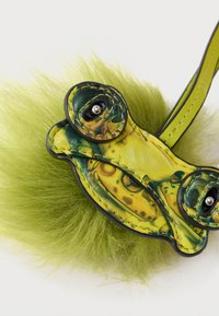 Πράσινο αξεσουάρ από ψεύτικη γούνα με σχέδιο βατράχου με κίτρινες και μαύρες λεπτομέρειες, μαύρα μεταλλικά στοιχεία και ρυθμιζόμενο λουρί.