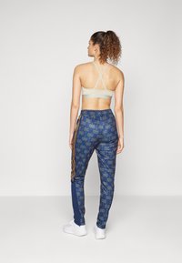 adidas Sportswear ADIDAS FARM RIO TIRO TRACK - Spodnji deli trenirk - bronze strata/dark marine/night indigo