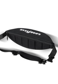 Black waist bag with padded design, featuring a textured surface, zip closure, adjustable nylon strap, and a prominent logo on the front.