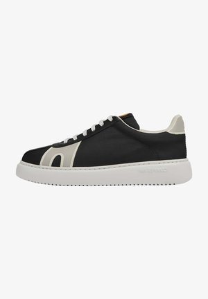 Czarne sneakersy z gładką tekstylną cholewką, białymi akcentami, okrągłym noskiem i grubą białą gumową podeszwą z teksturowanym bieżnikiem.