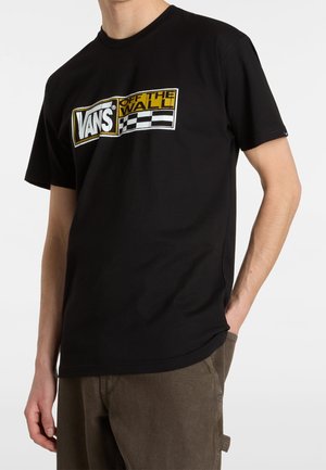 Sort bomuld T-shirt med en stor, fed gul og hvid "VANS Off the Wall"-logo med et ternet mønster nedenunder. Kortærmet.