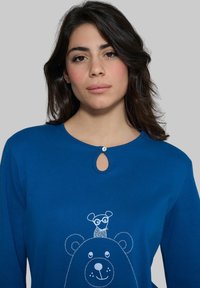 Felpa blu con maniche lunghe, dotata di scollo rotondo e dettaglio a chiave, decorata con un'illustrazione di un orso e un piccolo animale.