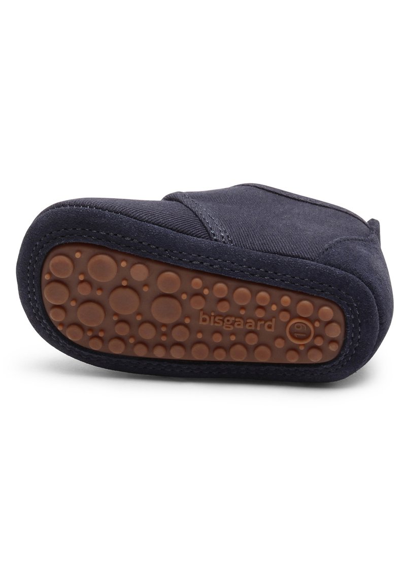 Marineblaue Schuhe mit einem weichen Stoffoberteil und einer flexiblen, strukturierten braunen Gummisohle mit kreisförmigen Grip-Mustern.