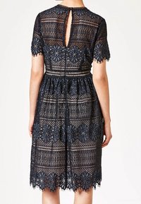 Navy-Blumenmusterkleid mit kurzen Ärmeln, offenem Rücken, taillierter Taille, einem ausgestellten Rock und gewelltem Saum.