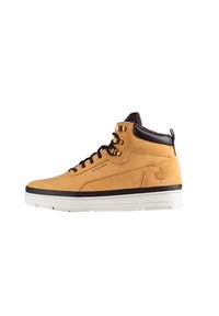 Sneaker alta in suede marrone con occhielli dorati, dettagli in pelle nera e suola in gomma bianca; presenta il logo sul tallone e una linguetta testurizzata.