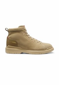 Baskets montantes en daim beige avec fermeture à lacets sur le devant, semelle beige, languette au talon et petit logo doré sur contrefort marron.