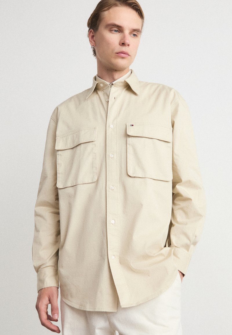 Beige langarm overhemd met knopen, gemaakt van katoen, met twee borstzakken en een zachte, gladde structuur. Slim fit met een minimalistisch ontwerp.
