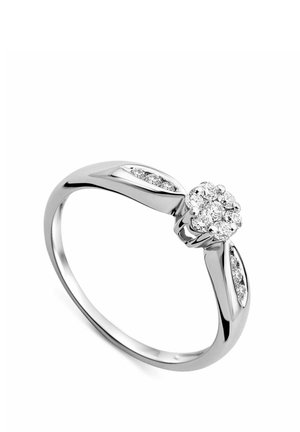 Anello d'argento con un gruppo rotondo di diamanti al centro e diamanti più piccoli incastonati lungo i lati rastremati della fascia.