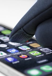 Juodas pirštinės antpirštis liečia išmaniojo telefono ekraną, kuriame rodomi įvairūs programėlių simboliai tamsiame fone.