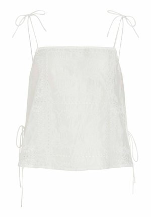 Blouse blanche sans manches avec bretelles à nouer et motifs floraux découpés brodés sur tissu léger.