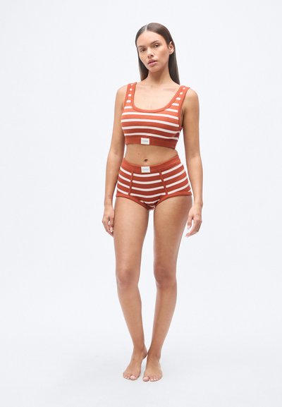 Σετ από ριγέ crop top και σορτς με ψηλή μέση σε χρώματα σκουριάς και κρεμ. Το υλικό φαίνεται μαλακό με εφαρμοστή σχεδίαση και αντίθετες ραφές.