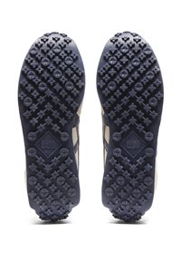 Suole delle scarpe con un design in gomma robusta caratterizzato da intricati motivi di tacco, in blu scuro con accenti chiari. Superficie texturizzata per una migliore aderenza.