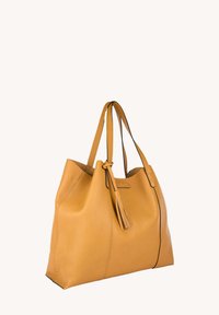 Sac fourre-tout en cuir jaune avec deux poignées, un accent à pompon et une forme incurvée. La surface présente une finition texturée et une couture contrastée.