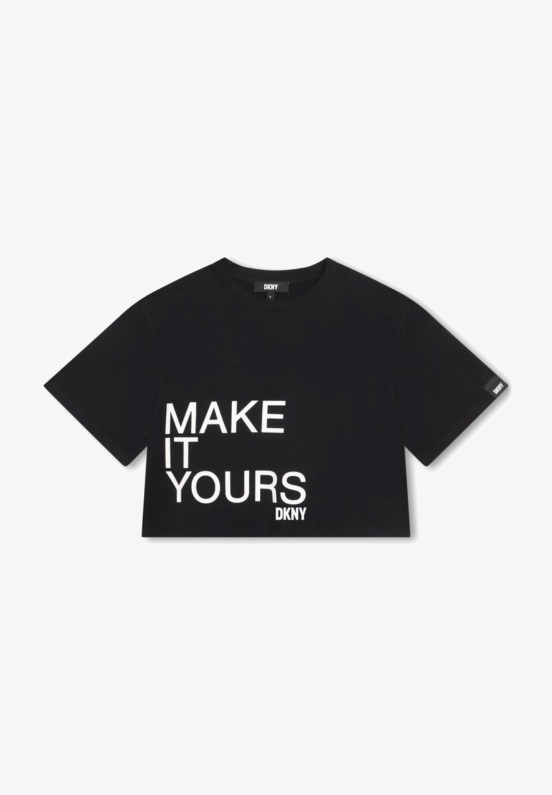 T-shirt noir court avec manches courtes, texte blanc disant "MAKE IT YOURS" et petits logos DKNY sur le devant et sur l'étiquette de la manche.