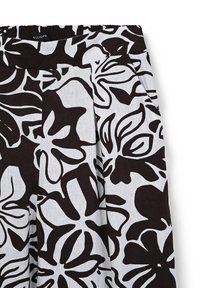 Black and white floral-patterned linen pants with an elastic waistband and pleats. Features bold, oversized flower designs.