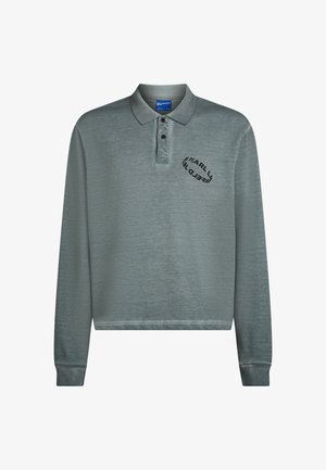 Langærmet polo i dæmpet teal med ribbet krave og manchetter. Sort logo broderi på brystet. Blødt, struktureret stof.