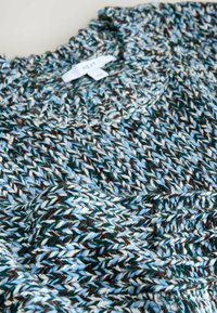 Jersey de punto en lana azul, marrón y crema. Cuello redondo acanalado. Textura distintiva con una mezcla de colores y diferentes grosores.