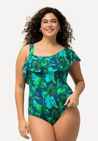 E�én stuk badpak in blauw en groen met een tropisch bladerenpatroon. Bevat één schouderband en een gerafelde accent langs de bovenrand.