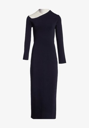 Robe noire à manches longues avec une silhouette ajustée et un décolleté asymétrique dévoilant une épaule.