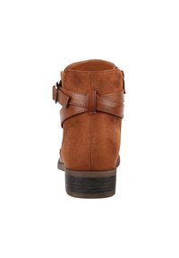 Stivali ankle in suede marrone con una cintura in pelle e un dettaglio con fibbia, tacco rettangolare basso, texture liscia e punta arrotondata.