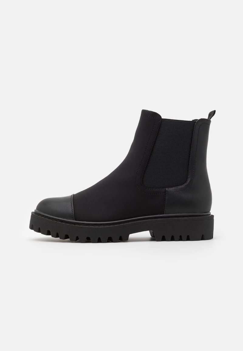Bottine noire en cuir avec panneau latéral élastique, bout arrondi, languette de tirage et semelle épaisse à crampons pour une bonne adhérence.