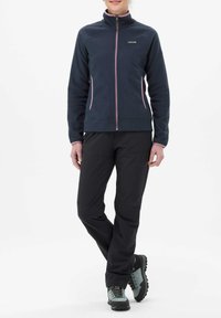 Chaqueta de forro polar azul oscuro con detalles en rosa, cierre de cremallera, cuello alto; pantalones negros; botas de senderismo grises con suelas negras. Textura suave en toda la prenda.
