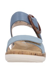 Blaue Ledersandale mit Korksohle und großer brauner runder Schnalle. Zwei minimalistische Riemen kreuzen den Vorderfuß und haben eine weiche Textur.