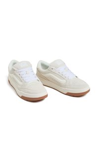 Baskets en suède blanc avec un bout rond, à lacets sur le devant, et une semelle extérieure en caoutchouc beige avec des détails perforés et un logo bien en vue sur la languette.