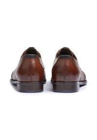 Scarpe in pelle marrone con superficie liscia, punta rotonda e tacco basso. Presentano un coprisedile nero e sottili dettagli di cucitura.