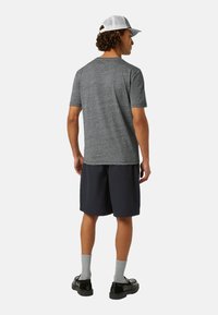Tricou gri cu mânecă scurtă, pantaloni scurți bleumarin cu textură, sosete gri și pantofi negri. Include o șapcă albă cu plasă pe spate.