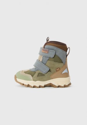 Botas de senderismo para niños en verde, marrón y azul. Presentan materiales de ante y textil, dos correas de velcro y una suela de goma texturizada.