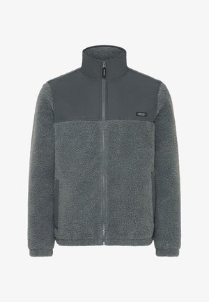 Fleecejakke i mørkegrå med en glatt overdelsseksjon, hel glidelås, høy krage og elastiske mansjetter. Har et teksturert, varmt materiale.