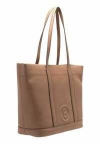 Bolso tote de cuero marrón claro con dos asas largas, superficie texturizada, costuras sutiles y un logo circular embosado en la parte frontal.