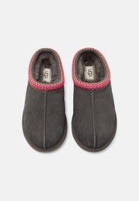 Chaussons en daim gris avec un col brodé rose et or, doté d'une doublure intérieure douce. Design à enfiler avec des orteils arrondis et des semelles plates.