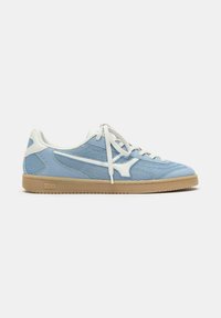 Hellblaue und weiße flache Sneaker mit Mesh-Seiten, weißen Schnürsenkeln und Gummisohle auf hellem einfarbigem Hintergrund.