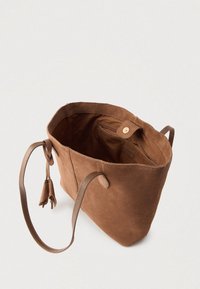 Καφέ τσάντα ώμου από σουέντ με απαλή υφή, δύο λαβές μεταφοράς και εσωτερική τσέπη, με κούμπωμα με κουμπί και διακοσμητικές φούντες.