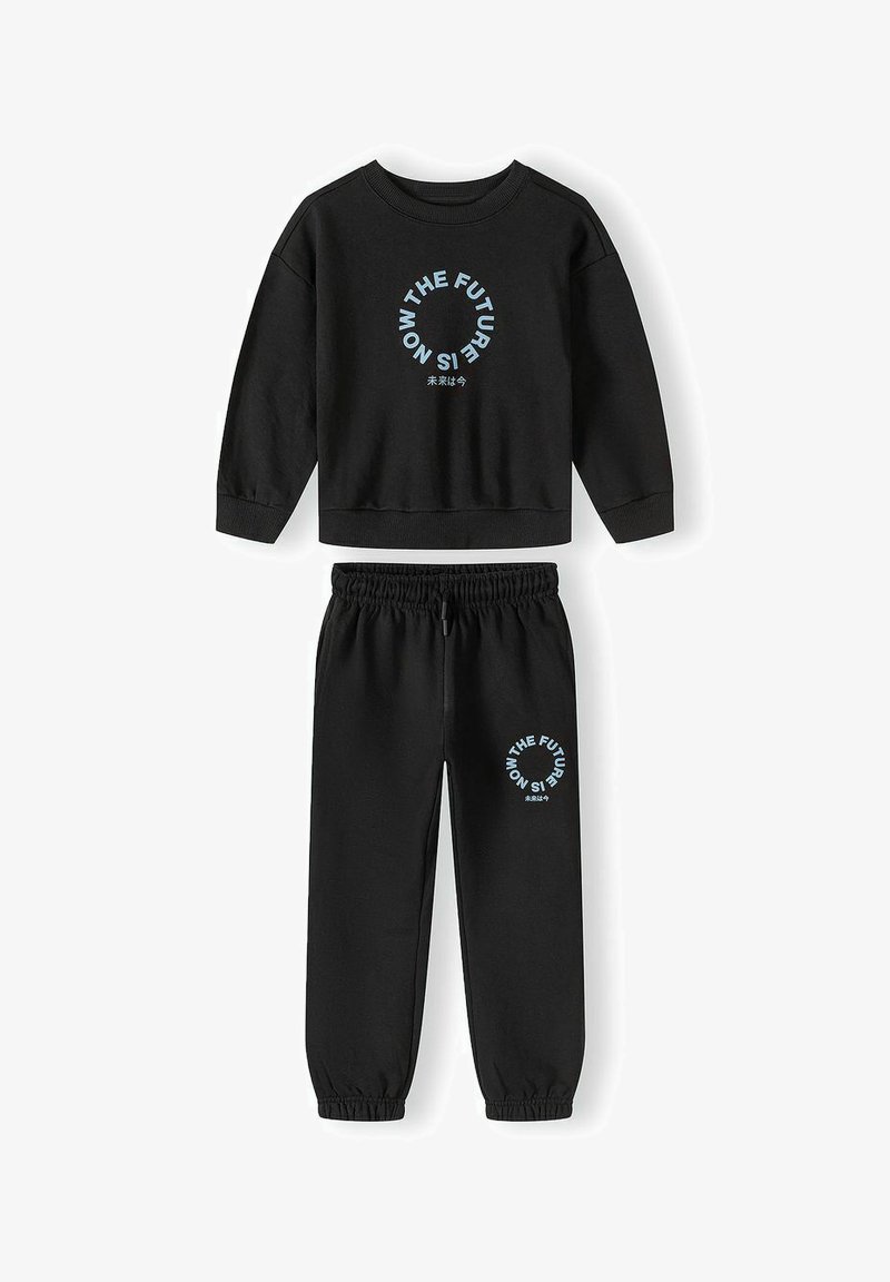 Ensemble sweat-shirt noir et joggings avec texte circulaire bleu clair « THE FUTURE IS NOW » et petits caractères japonais sur les deux pièces.
