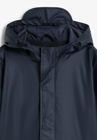 Chaqueta impermeable azul marino con capucha, que cuenta con botones a presión y cordones ajustables. Textura suave con forro interior acolchado.