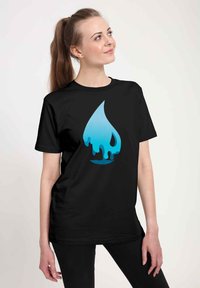 Ung kvinde med lang brun hestehale iført en sort T-shirt med et stort design af drippende blå vanddråbe.