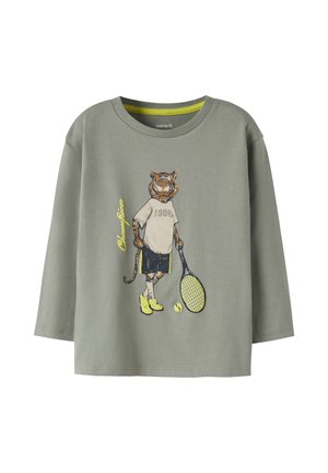 Hellgraues Langarmshirt mit Grafik eines Tigers in Sportbekleidung, der einen Tennisschläger und -ball hält, mit den Texten "1986" und "Champion".