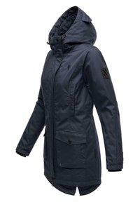 Navy blue parka with a hood, zip and button closure, two front pockets, and a black fabric patch on the sleeve. Smooth exterior texture.