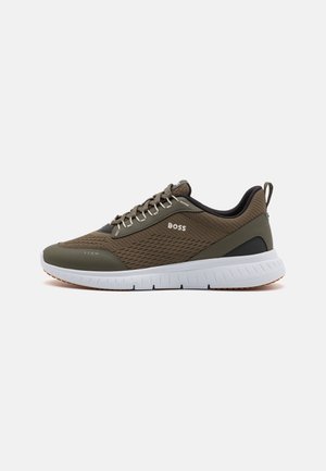 Oliven grøn og sort BOSS sneaker med mesh-overdel, hvid sål, snøredesign og træk-flig på en ens hvid baggrund.