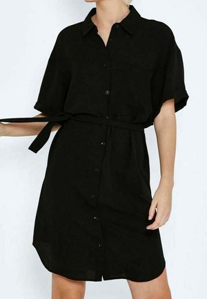 Zwarte jurk met korte mouwen, knoopsluiting, kraag en ceintuur in de taille, gedragen door een persoon die van de schouders tot de knieën te zien is.