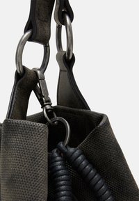 Černá texturovaná taška s nylonovými rukojeťmi, kovovými detaily a vinutým akcentem. Má strukturovaný tvar a odolnou látku.