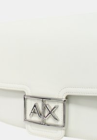 Borsa a mano in pelle bianca con una fibbia rettangolare in argento che presenta il logo "AX". Texture liscia e design minimalista, accentuato da dettagli cuciti.